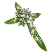 A solemn, elegant floral cross photographed against a clean white backdrop from a gentle overhead angle, offering a quiet, isolated study of form and texture. The structural silhouette of the Christian cross is built from broad, glossy tropical Ti leaves whose deep green surfaces catch a soft, even light and reveal their prominent veins and waxy sheen; the leaves are layered and overlapped to create the defined vertical and horizontal arms. At the heart of the cross and running delicately along each arm is a concentrated carpet of pale blooms in a restrained palette of soft white, creamy ivory and whispering lavender. Ruffled lisianthus with layered, satiny petals and tender closed buds sit alongside small, rounded white chrysanthemum sprays that bring gentle brightness and cushiony texture. Interspersed through the clusters are tiny, star-shaped lavender or light-purple sprays-likely limonium or small asters-that give a faint cool contrast and a sense of depth. Fine green filler foliage is threaded through the flowers, softening edges and enhancing the natural, heartfelt feel. The overall scent is subtle, green and slightly floral, more a memory than an impression, and the composition conveys reverence, calm and respectful remembrance. This arrangement is crafted for sympathy and memorial settings-funeral chapels, church services, and graveside tributes-and would be offered by local florists serving North Ockendon and neighboring communities to express condolence with dignity and serene beauty. The careful layering, color balance and tactile contrasts create a reassuring visual embrace, a classic tribute meant to signify peace and enduring memory.